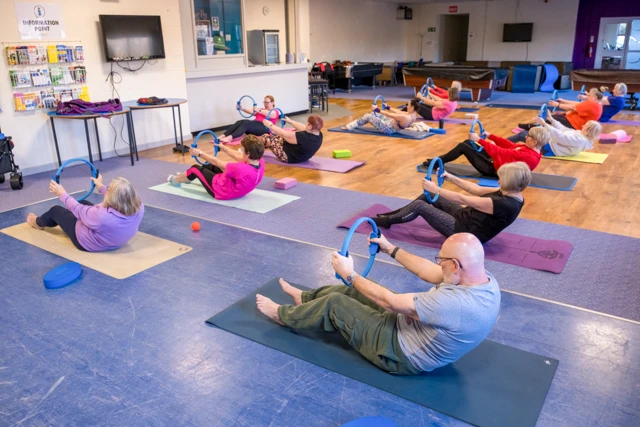 Pilates (11) Instructor and participants using magic circle in Pilates class