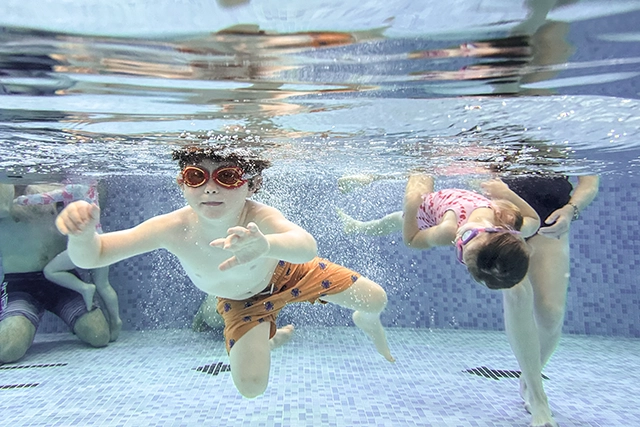 Parent and Toddler Swim Two toddlers swim underwater.