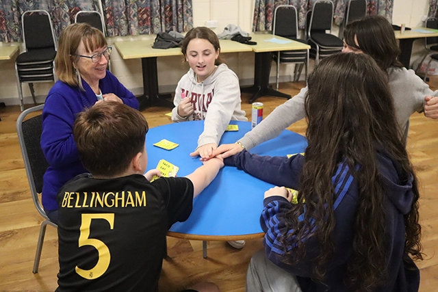 Rock Solid web A group sit around a table playing a card game at youth club