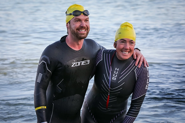 Solent swimmers Two smiling swimmers in wetsuits.